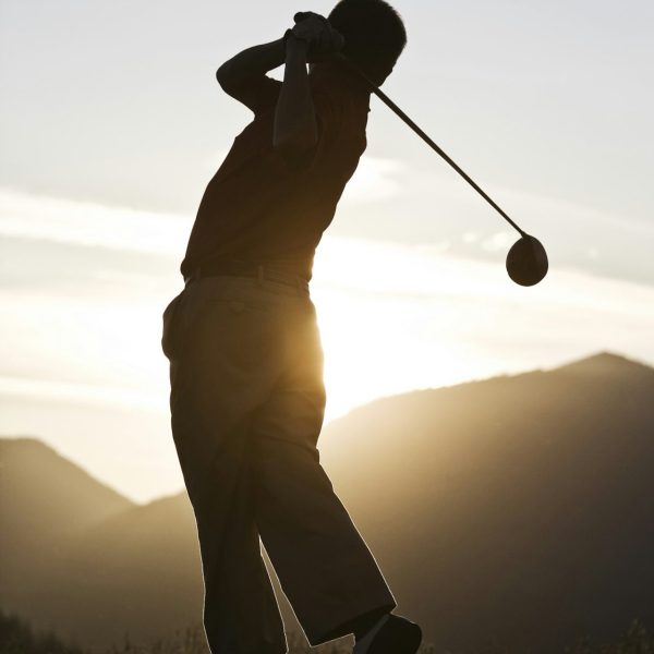 senior-golfer-teeing-off-at-sunset-.jpg